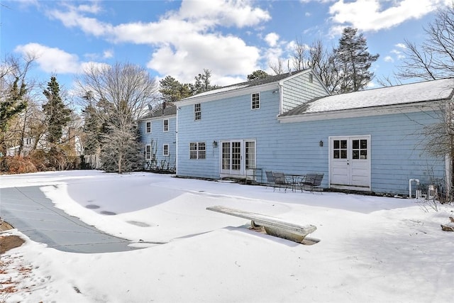 view of snow covered rear of property