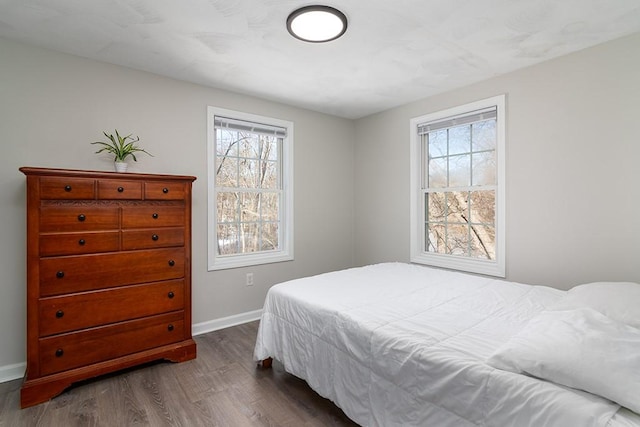 bedroom featuring dark wood-style floors and baseboards