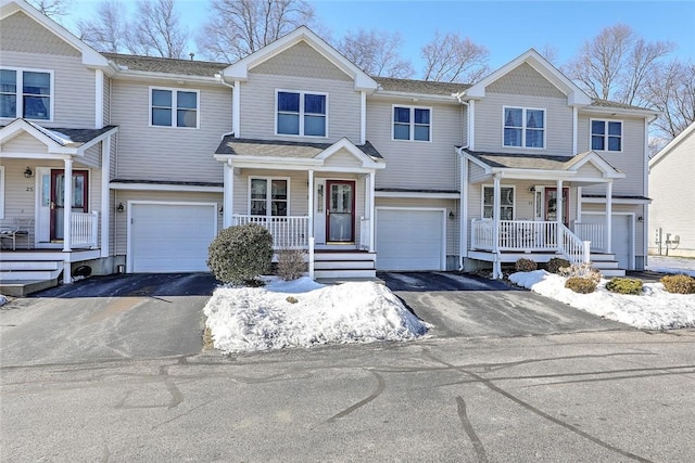 view of front of home with driveway, a porch, and an attached garage