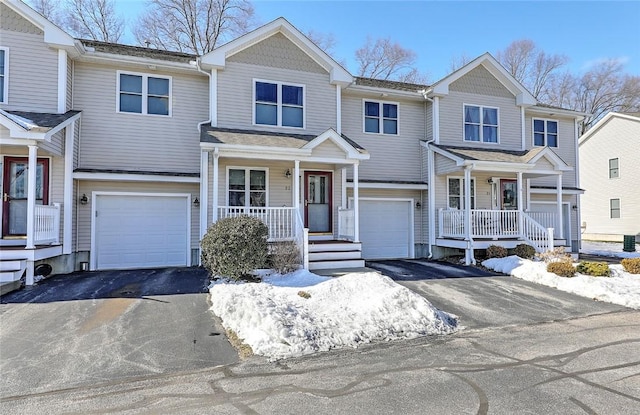 view of front of property with aphalt driveway, a porch, and an attached garage