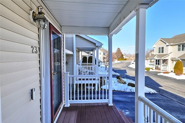 wooden terrace featuring a porch and a residential view