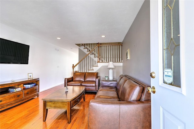 living area with recessed lighting, stairway, baseboards, and wood finished floors