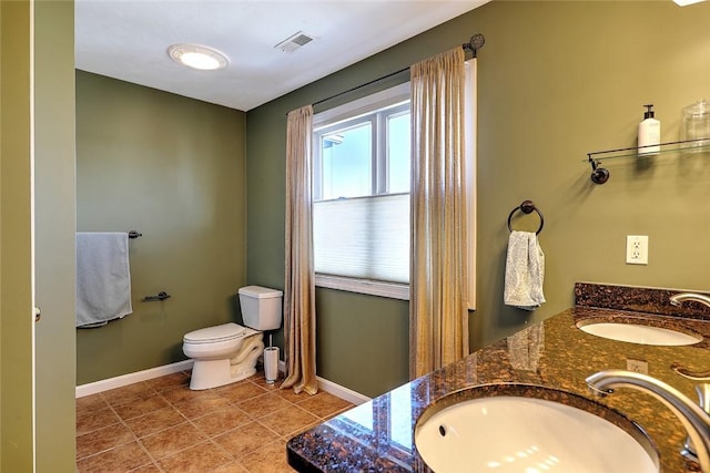 bathroom featuring double vanity, baseboards, visible vents, and a sink