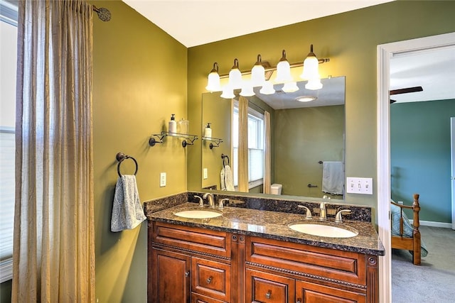 bathroom featuring toilet, a sink, ensuite bath, and double vanity