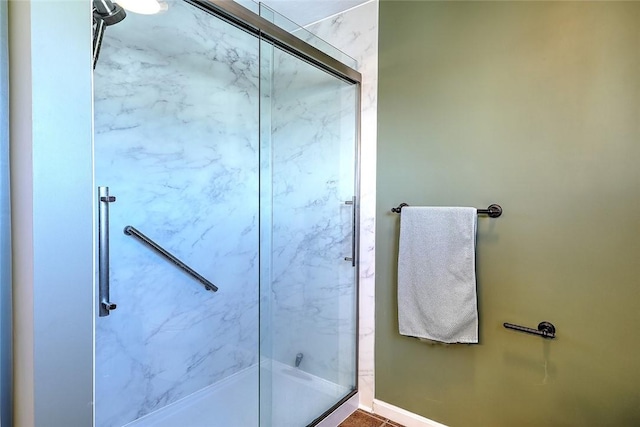 full bathroom with baseboards and an enclosed shower