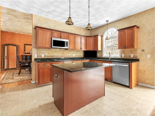 kitchen featuring a kitchen island, backsplash, stainless steel appliances, and a sink