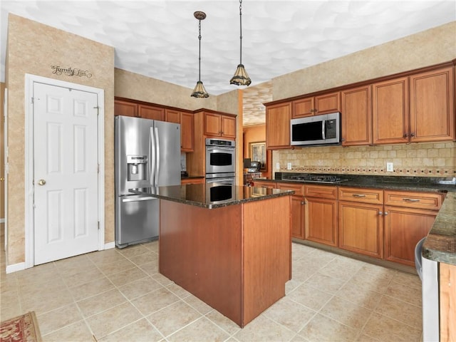 kitchen featuring dark stone countertops, a kitchen island, stainless steel appliances, tasteful backsplash, and brown cabinets