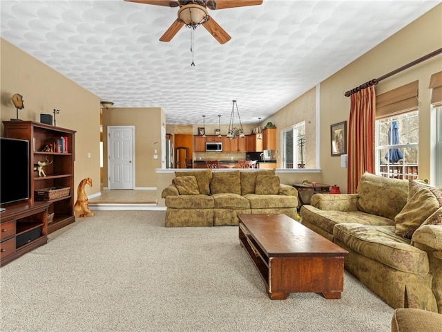 living room with baseboards, light carpet, and ceiling fan