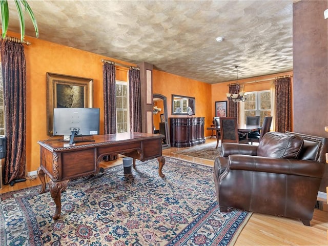 office with a notable chandelier, baseboards, and wood finished floors