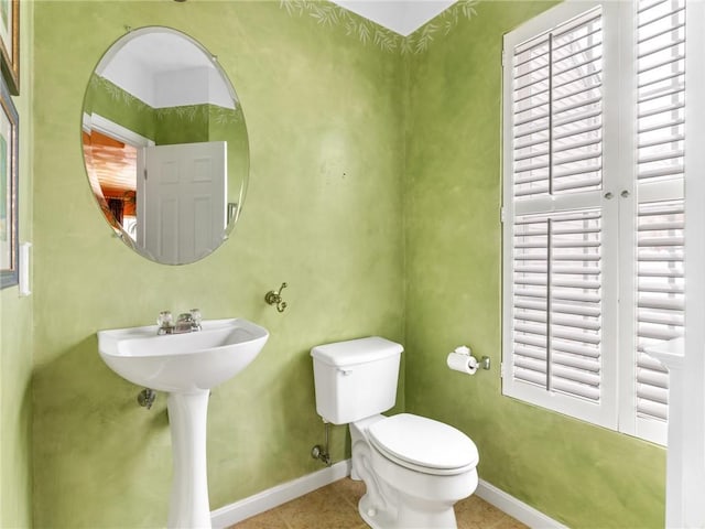 bathroom with tile patterned floors, baseboards, and toilet