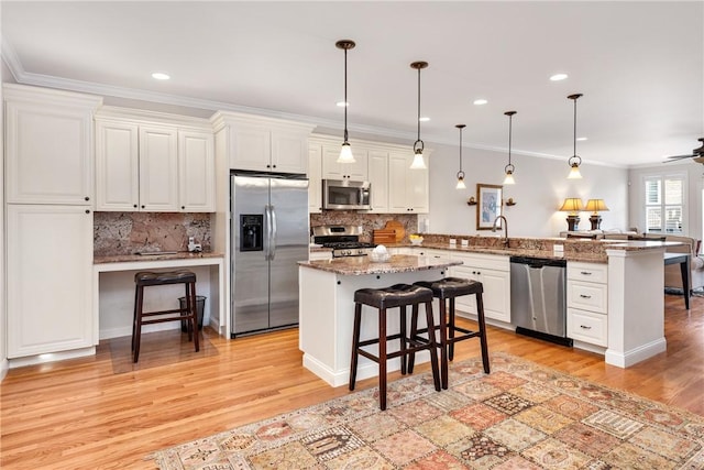 kitchen featuring stainless steel appliances, a peninsula, a kitchen island, a kitchen breakfast bar, and decorative light fixtures