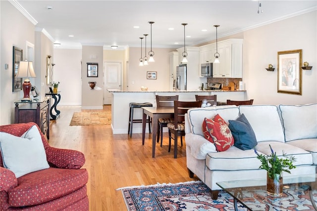 living room featuring recessed lighting, crown molding, light wood-style flooring, and baseboards