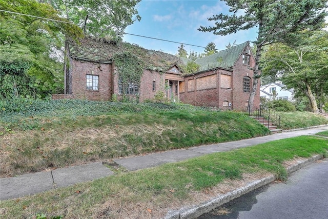 tudor home featuring brick siding