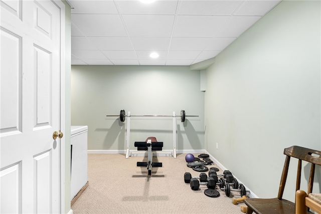 exercise area with carpet floors, washer / clothes dryer, a drop ceiling, and baseboards