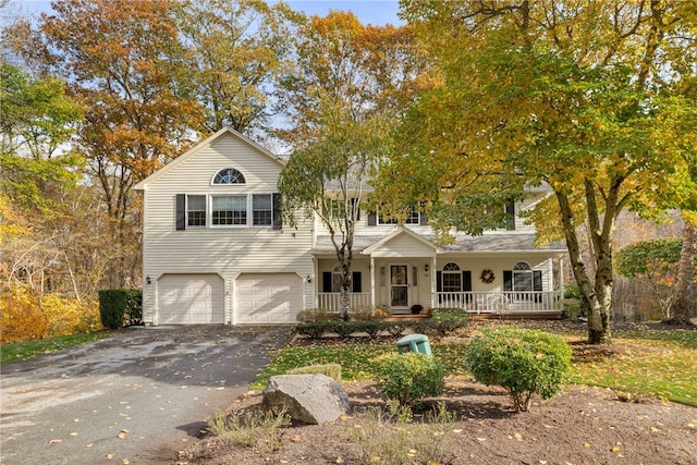 view of front facade with covered porch, driveway, and an attached garage