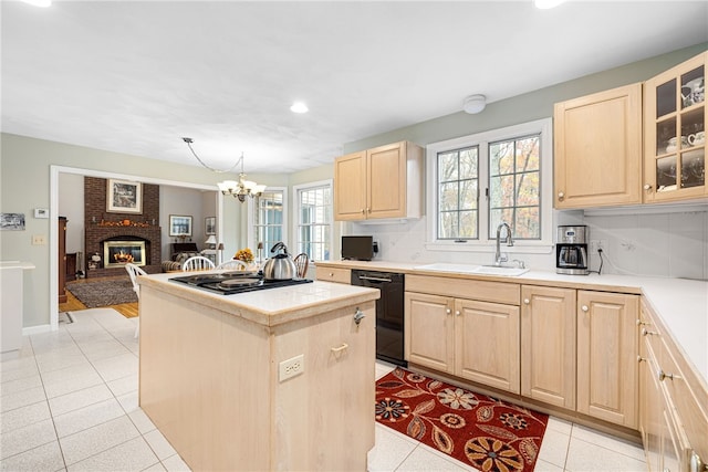 kitchen with a center island, glass insert cabinets, light brown cabinets, a sink, and dishwasher