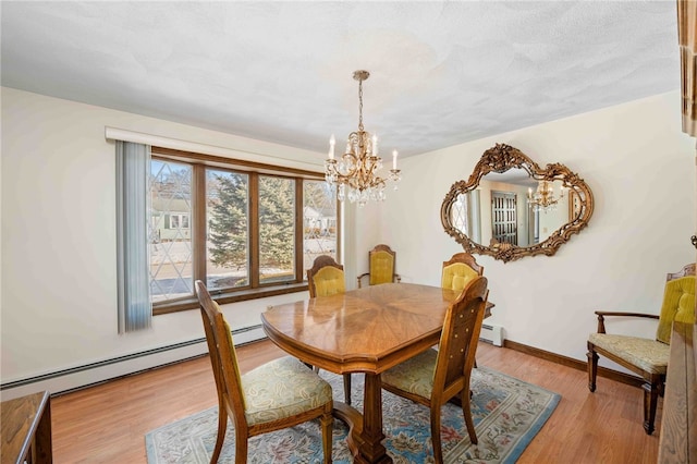 dining space featuring baseboards, light wood-type flooring, and a notable chandelier