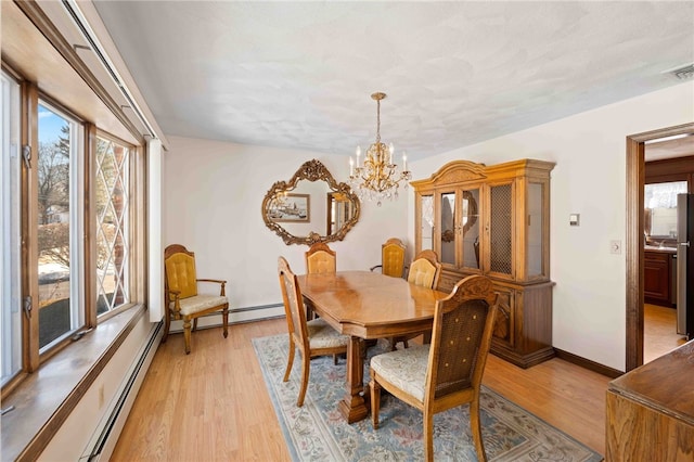 dining area with baseboards, visible vents, an inviting chandelier, light wood-style floors, and a baseboard heating unit