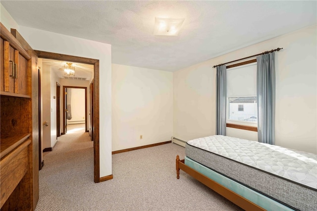 bedroom featuring a baseboard heating unit, light colored carpet, and baseboards