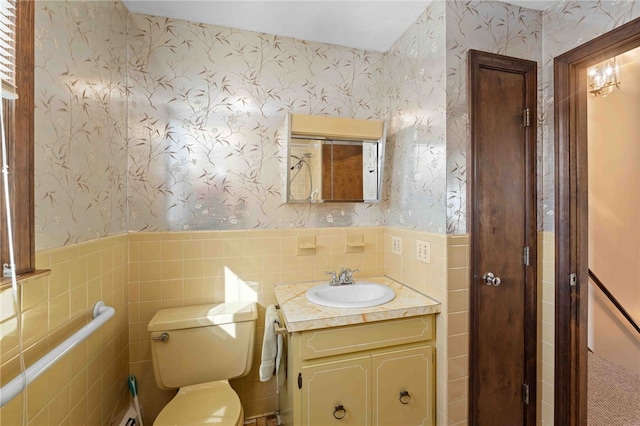 bathroom with wainscoting, vanity, and wallpapered walls