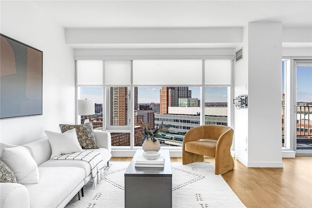 living area featuring a view of city, baseboards, and light wood finished floors