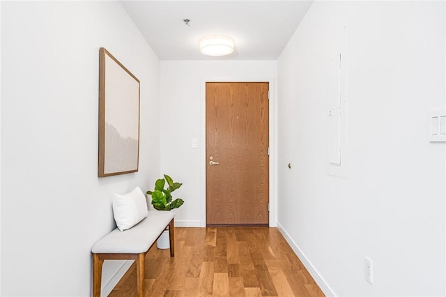 doorway to outside with light wood-type flooring and baseboards