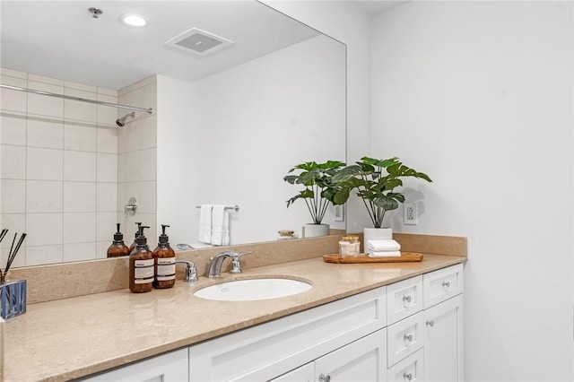 bathroom with visible vents, walk in shower, and vanity