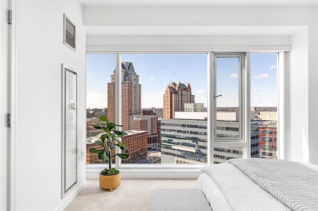 bedroom with a view of city, visible vents, and carpet flooring