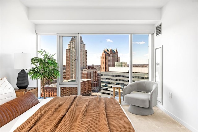 carpeted bedroom featuring baseboards, access to outside, visible vents, and a city view