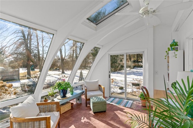 sunroom featuring lofted ceiling with skylight and ceiling fan