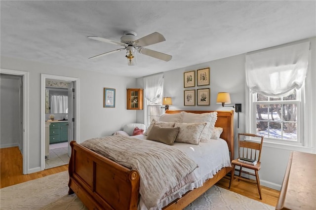 bedroom featuring a ceiling fan, light wood-type flooring, and baseboards