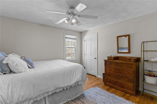 bedroom with baseboards, ceiling fan, and light wood finished floors