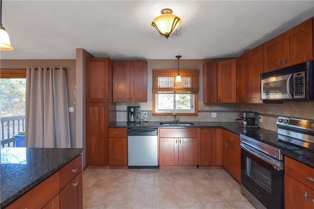 kitchen featuring stainless steel appliances, pendant lighting, brown cabinets, and a sink