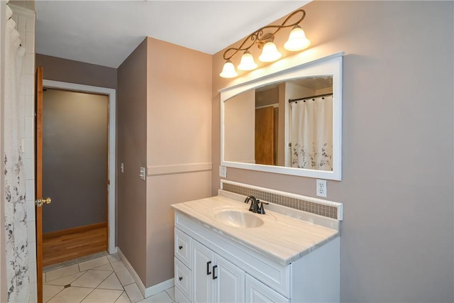 bathroom with tile patterned floors, baseboards, and vanity