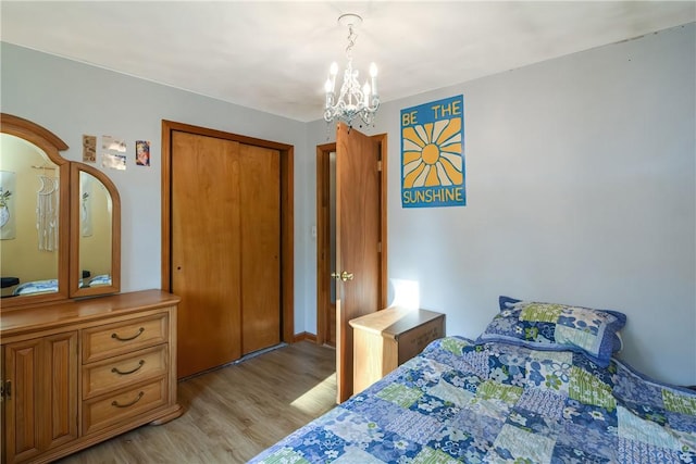 bedroom featuring light wood-style floors, a closet, and a notable chandelier