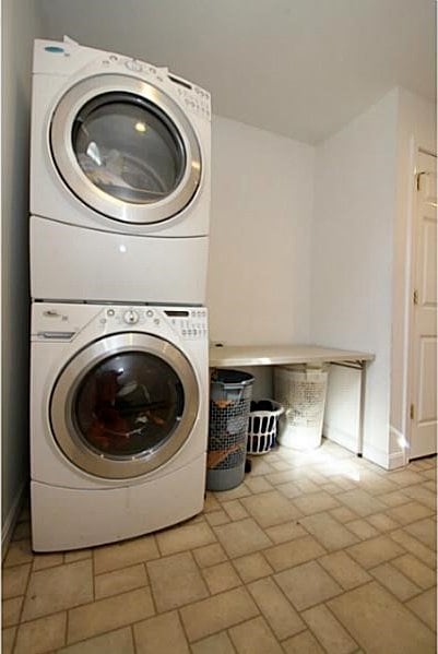 laundry room with stacked washer / dryer and laundry area