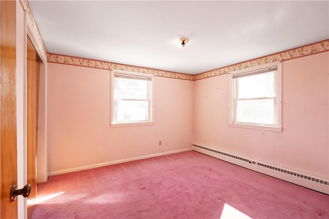 unfurnished room with baseboards, a baseboard heating unit, and light colored carpet