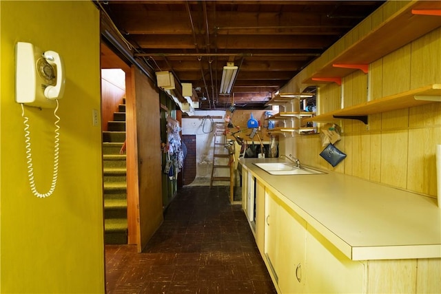 unfinished basement featuring stairs and a sink