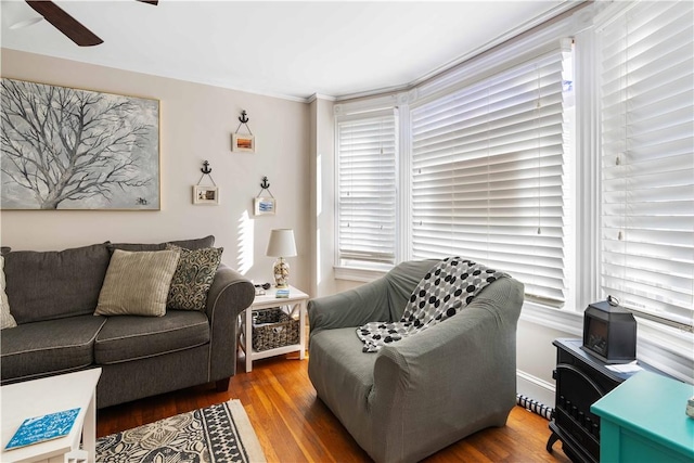 living area with plenty of natural light, wood finished floors, and a ceiling fan