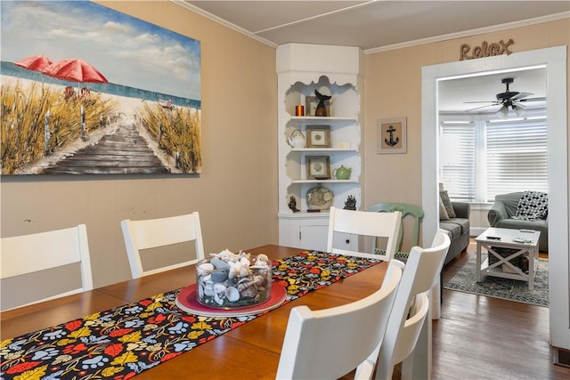 dining area with dark wood-style floors, ceiling fan, and ornamental molding