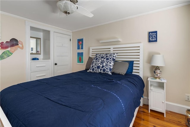 bedroom featuring ceiling fan, baseboards, crown molding, and wood finished floors