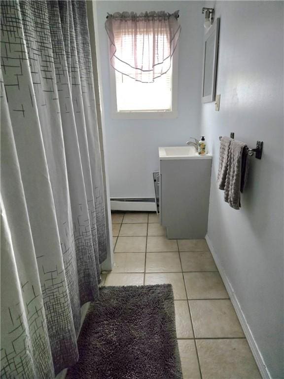 full bath with baseboard heating, tile patterned flooring, vanity, and baseboards