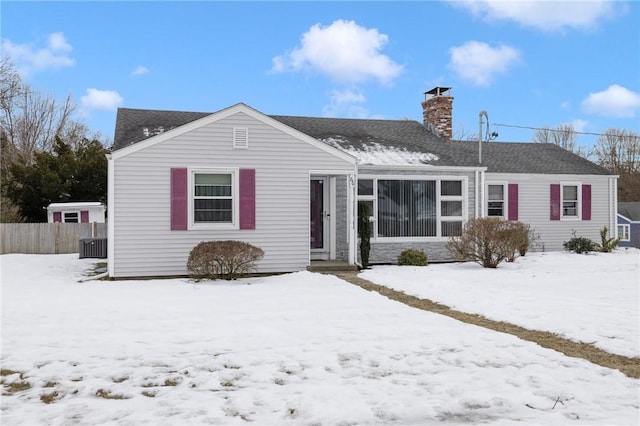 single story home featuring a shingled roof and a chimney