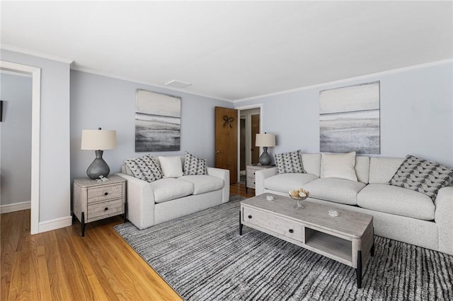 living area featuring ornamental molding, wood finished floors, and baseboards