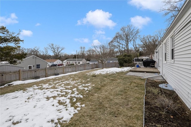 yard covered in snow featuring a fenced backyard and a residential view