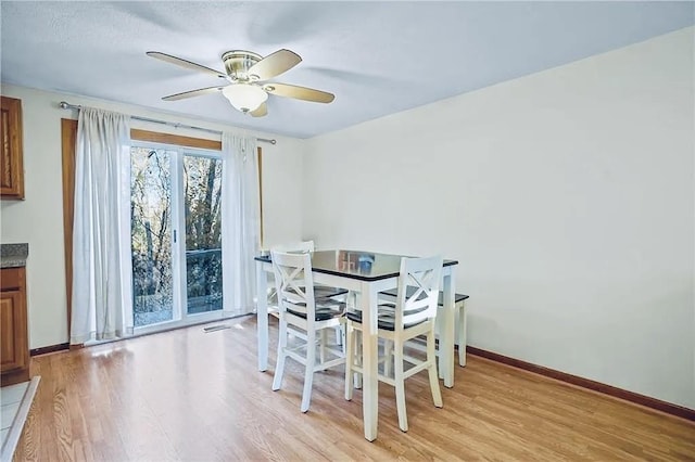 dining area featuring light wood-style floors, ceiling fan, and baseboards