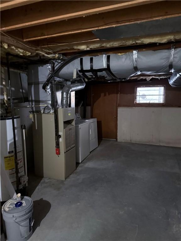 basement featuring water heater and separate washer and dryer