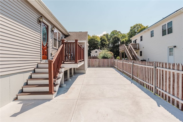 view of patio with stairway and fence