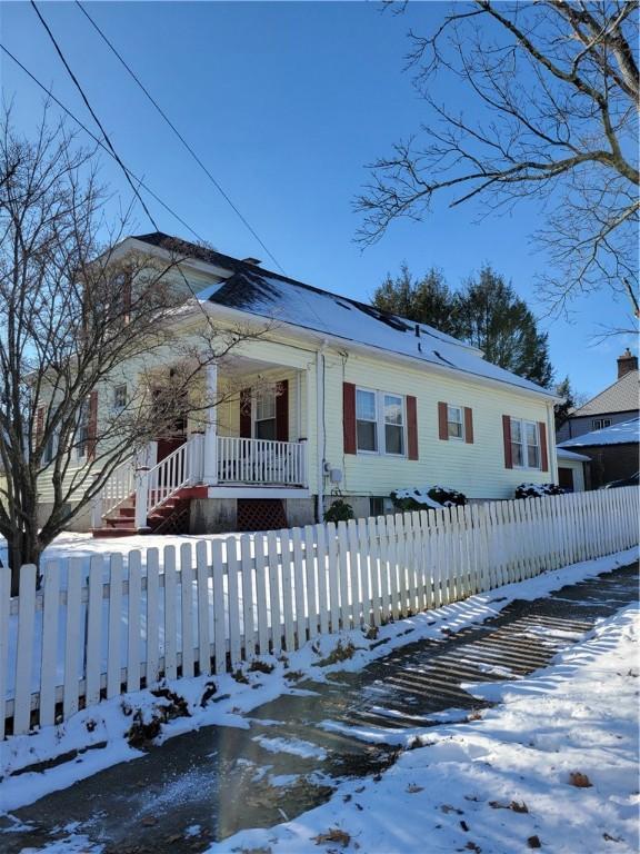 view of front of house featuring covered porch and a fenced front yard