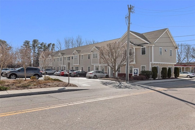 view of building exterior featuring uncovered parking and a residential view